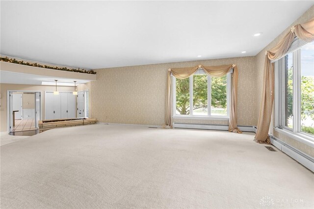 unfurnished living room with a wealth of natural light and carpet flooring