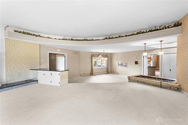 unfurnished living room featuring baseboard heating and light carpet