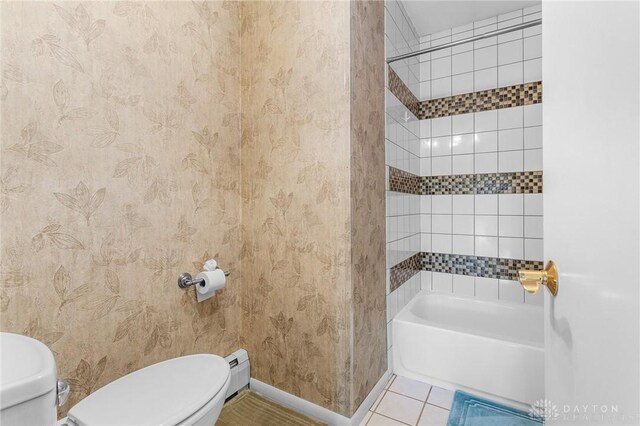 bathroom featuring tiled shower / bath, toilet, a baseboard radiator, and tile patterned flooring