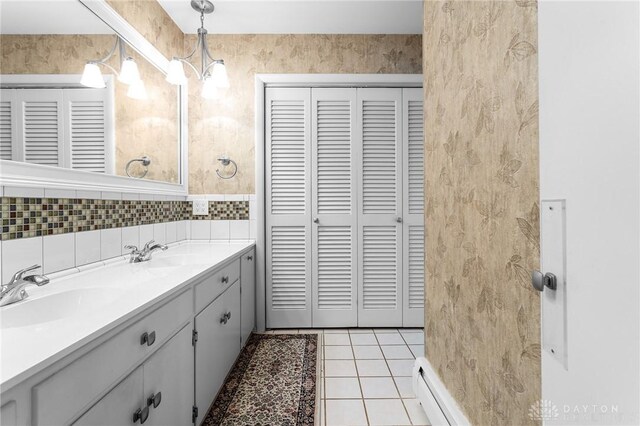 bathroom with vanity, tasteful backsplash, tile patterned floors, and a notable chandelier