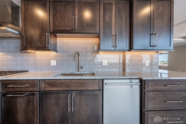 kitchen with wall chimney exhaust hood, light stone counters, dark brown cabinets, and a sink