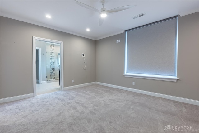 spare room featuring ornamental molding, light colored carpet, visible vents, and baseboards