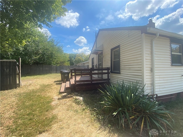 view of home's exterior with a yard and a deck