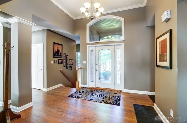 foyer entrance featuring crown molding, a notable chandelier, and hardwood / wood-style floors