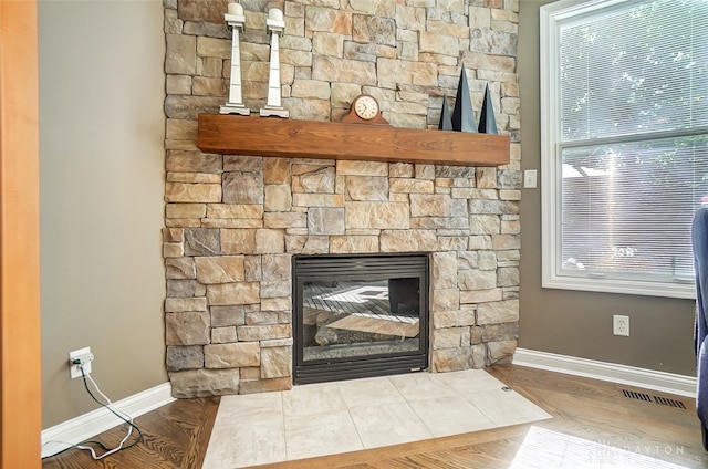 interior details featuring hardwood / wood-style flooring and a stone fireplace