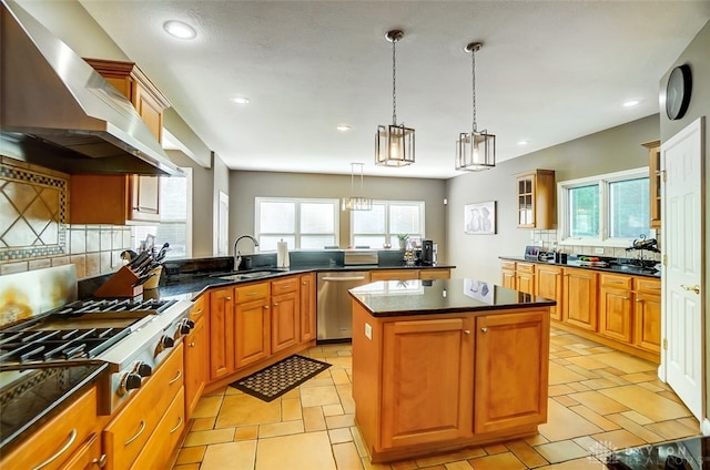 kitchen with a healthy amount of sunlight, sink, wall chimney range hood, and a kitchen island