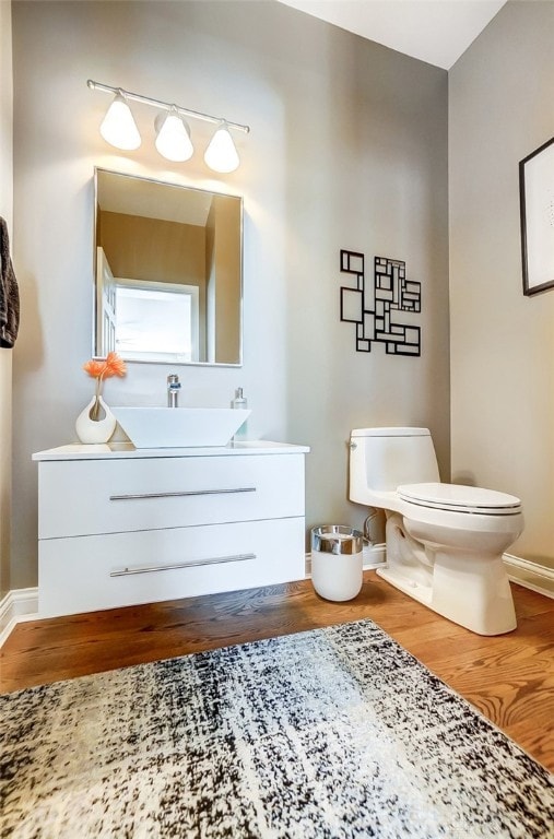 bathroom featuring vanity, toilet, and hardwood / wood-style floors