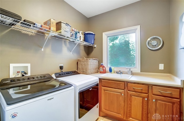 laundry room featuring cabinets, washer and clothes dryer, and sink