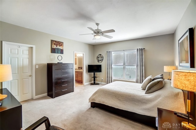 bedroom with light colored carpet, ensuite bathroom, and ceiling fan