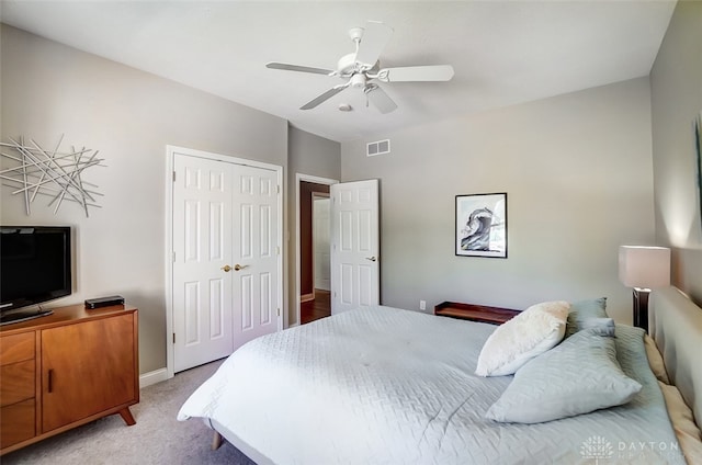 carpeted bedroom with ceiling fan and a closet