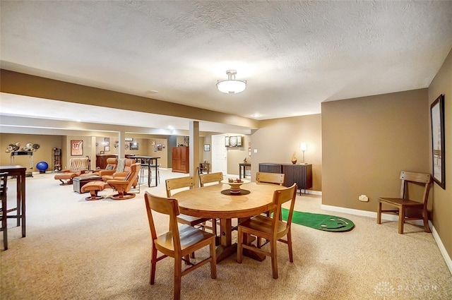 dining area featuring a textured ceiling and carpet flooring