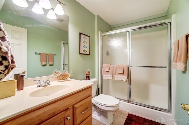 bathroom featuring tile patterned floors, toilet, a shower with door, and vanity