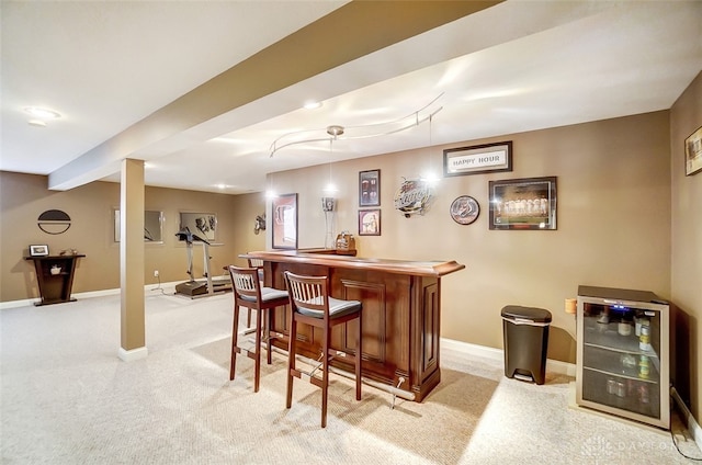 bar with light carpet, wine cooler, and hanging light fixtures