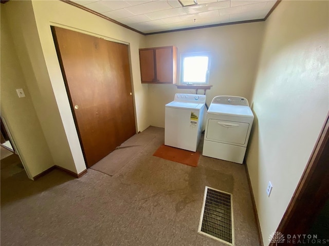 laundry area featuring washing machine and clothes dryer, light carpet, and ornamental molding