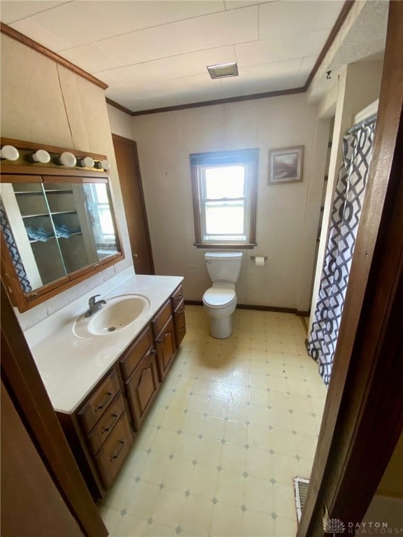 bathroom featuring a shower with shower curtain, toilet, crown molding, and vanity