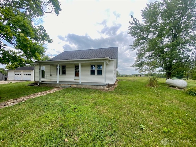 view of front of house with a garage, covered porch, and a front lawn