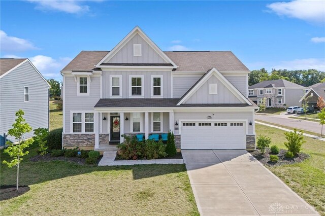 craftsman-style house with a front lawn, a garage, and covered porch