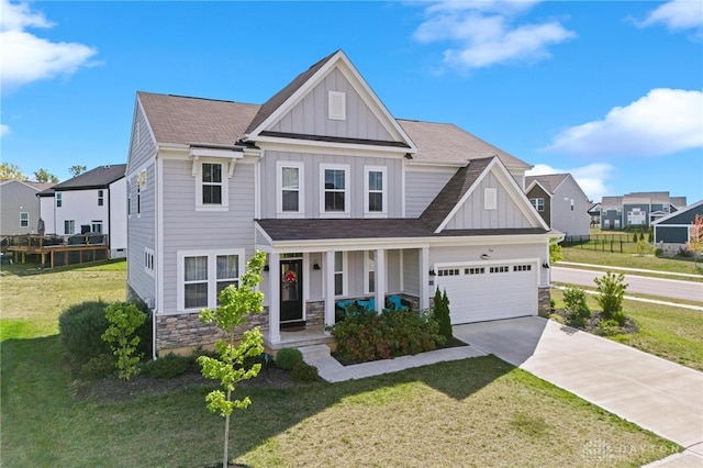 craftsman inspired home with a front lawn, a garage, and covered porch