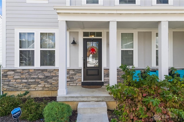 view of exterior entry featuring covered porch