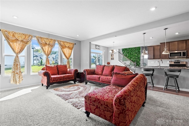 living room with hardwood / wood-style flooring, a chandelier, and a healthy amount of sunlight