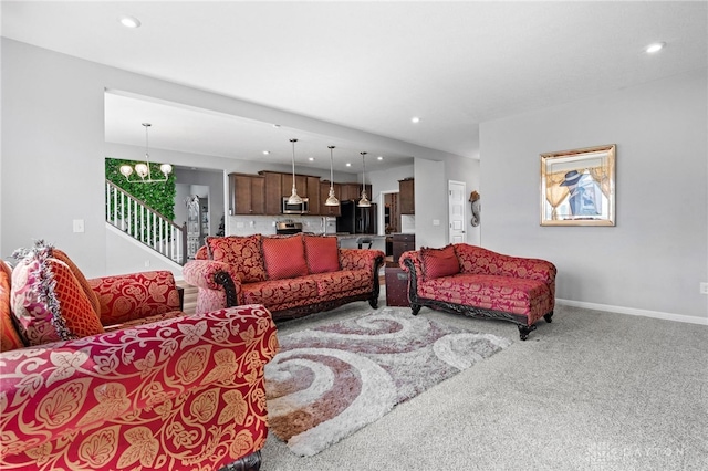 carpeted living room with an inviting chandelier