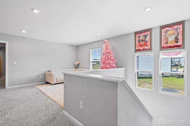 hallway with a wealth of natural light and carpet flooring