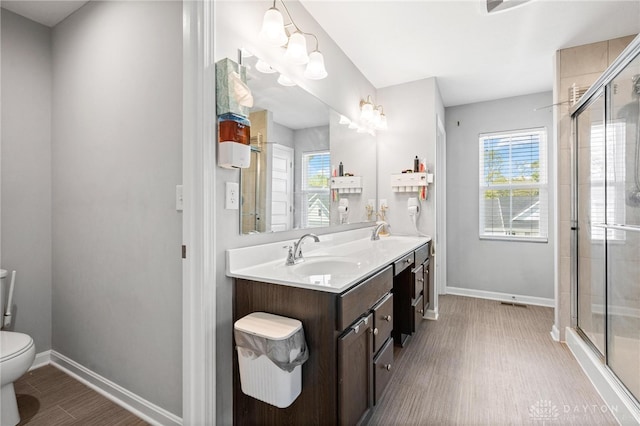 bathroom with vanity, toilet, walk in shower, and hardwood / wood-style floors