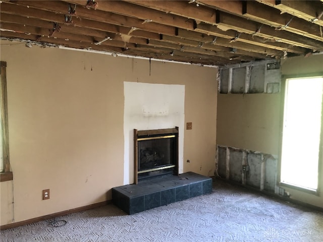 unfurnished living room featuring a tile fireplace