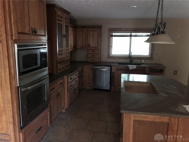 kitchen featuring a textured ceiling, dark tile patterned floors, sink, and stainless steel appliances