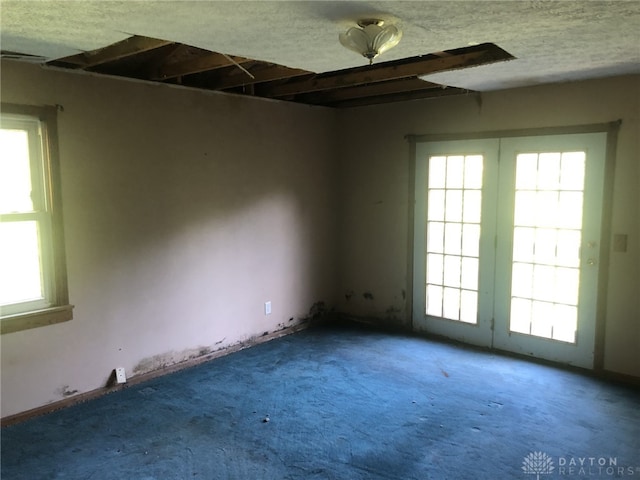 carpeted empty room featuring a textured ceiling