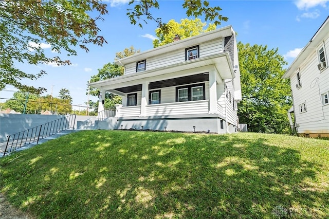 rear view of property featuring a porch and a lawn