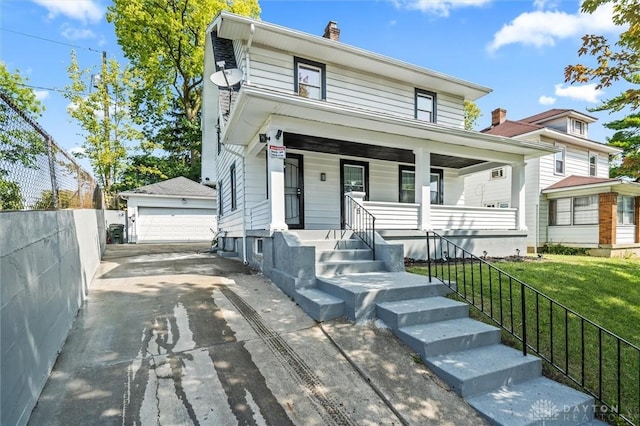 view of front of property featuring an outbuilding, a garage, a front lawn, and a porch