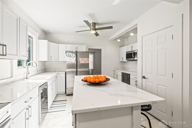 kitchen featuring sink, a center island, white cabinets, and appliances with stainless steel finishes