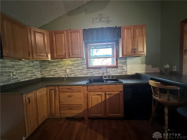 kitchen with sink, vaulted ceiling, decorative backsplash, black dishwasher, and dark hardwood / wood-style flooring