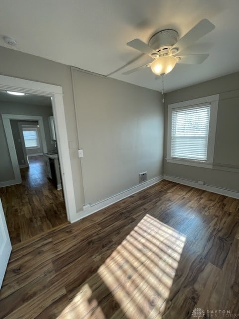 empty room with ceiling fan and dark wood-type flooring