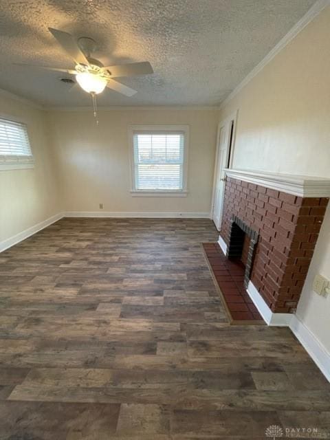 unfurnished living room featuring a textured ceiling, a fireplace, dark hardwood / wood-style floors, ornamental molding, and ceiling fan