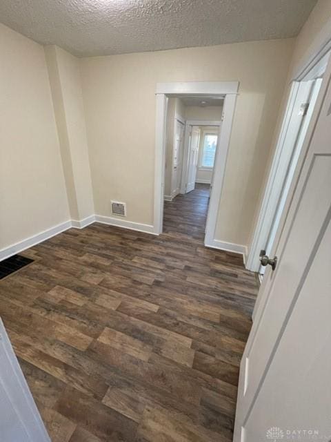 empty room featuring dark hardwood / wood-style floors and a textured ceiling