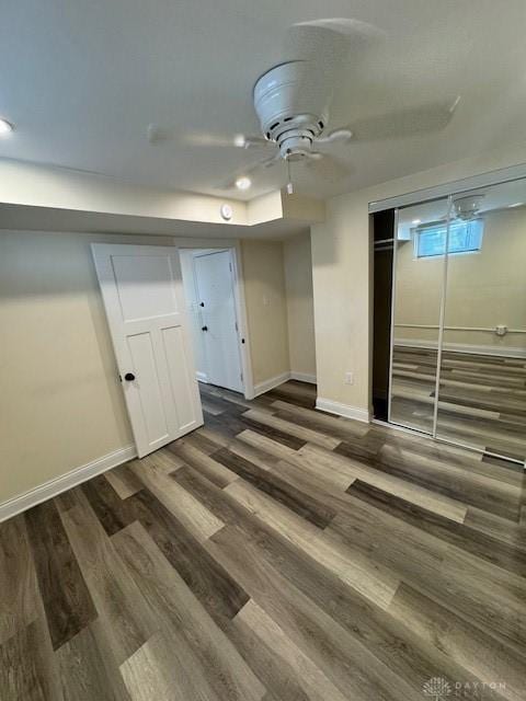 basement with ceiling fan and dark hardwood / wood-style flooring