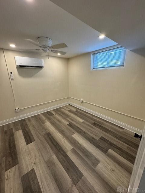 basement with dark wood-type flooring and a wall unit AC