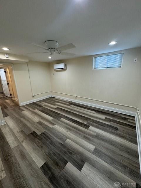 basement featuring an AC wall unit and dark hardwood / wood-style flooring