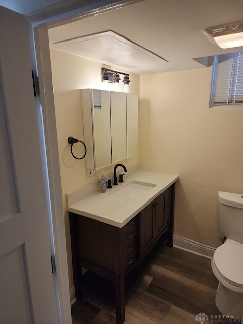 bathroom featuring toilet, vanity, and wood-type flooring