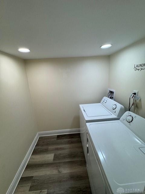 clothes washing area with washer and dryer and dark hardwood / wood-style flooring