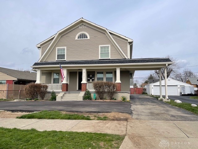 view of front of house with covered porch, a garage, and an outdoor structure