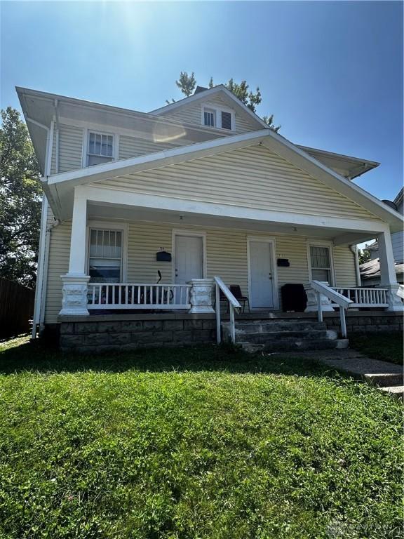 view of front of property with covered porch and a front yard