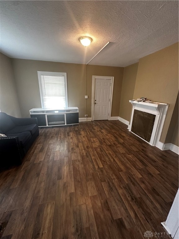 entrance foyer featuring a textured ceiling, dark hardwood / wood-style flooring, and a fireplace