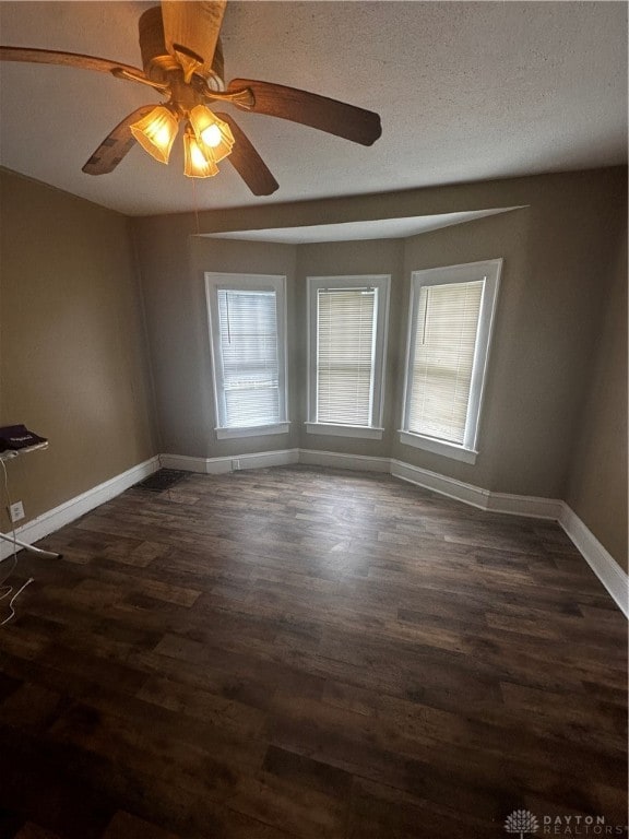 unfurnished room featuring a textured ceiling, ceiling fan, and dark hardwood / wood-style floors