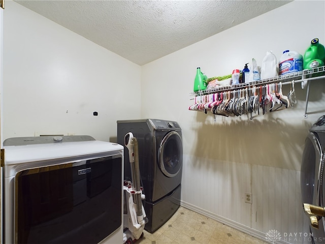 washroom with a textured ceiling and washer and dryer