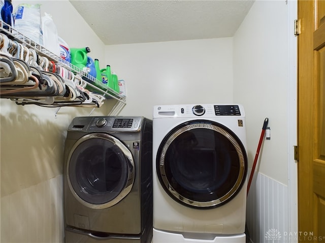 washroom with a textured ceiling and separate washer and dryer