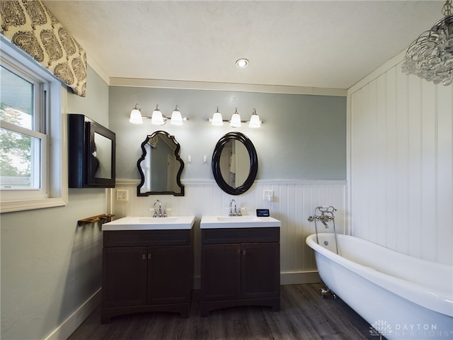 bathroom featuring a textured ceiling, hardwood / wood-style floors, a bath, vanity, and ornamental molding