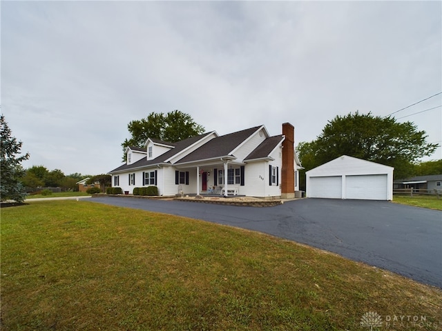 view of front of house featuring an outbuilding, a garage, covered porch, and a front yard